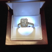 custom 1.80ct emerald radiant cut diamond surrounded by 1.42ct smaller diamonds all set in 18kt white gold