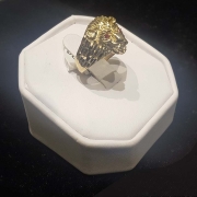 mans custom gold lion head ring with red eyes