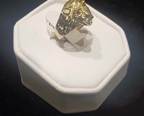 mans custom gold lion head ring with red eyes