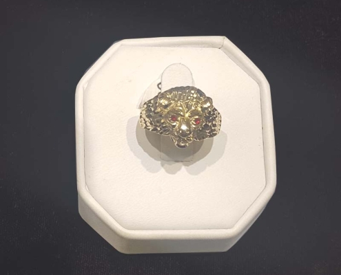 mans custom gold lion head ring with red eyes