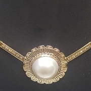 Mabé pearl is on a 14k gold chain with diamonds surrounding the pearl and extending up the chain